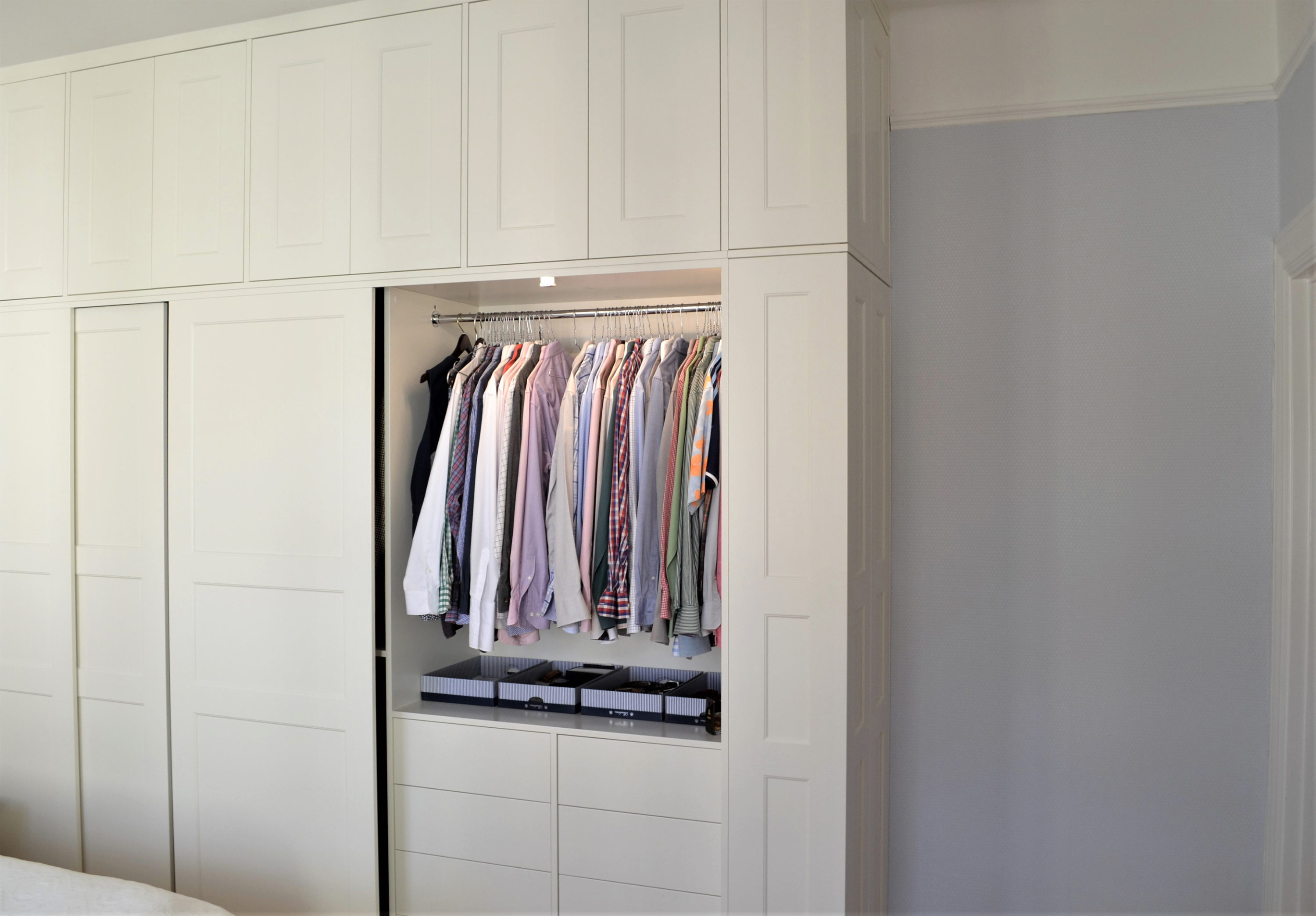 Garderobsförvaring från golv till tak Vacker vit platsbyggd garderob med skjutdörrar