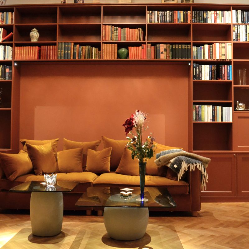 Platsbyggt-fran-vagg-till-vagg-runt-soffa.-Laga-tradorrar-nedtill-samt-barskap-till-hoger-scaled